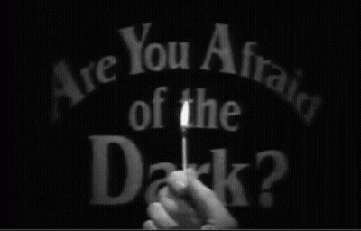 A Person Is Holding A Stick In Front Of The Words Are You Afraid Of The Dark ? GIF