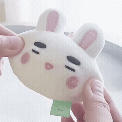 A Person Is Holding A Stuffed Animal In The Shape Of A Bunny Rabbit GIF