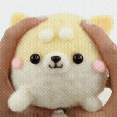 A Person Is Holding A Stuffed Animal In Their Hands That Looks Like A Shiba Inu Dog . GIF