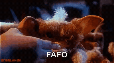 A Person Is Holding A Stuffed Animal That Looks Like A Gremlin From Gremlins . GIF