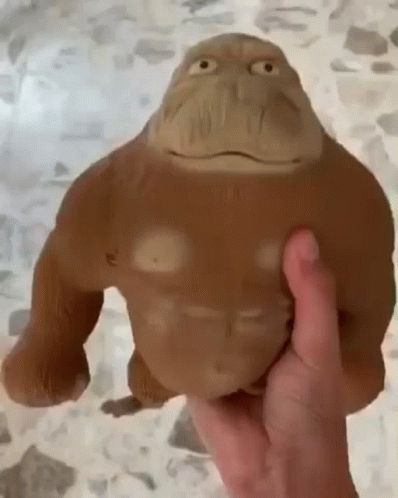 A Person Is Holding A Stuffed Animal That Looks Like A Monkey . GIF