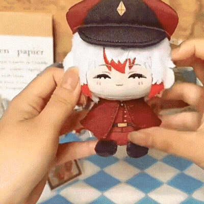 A Person Is Holding A Stuffed Doll Wearing A Hat And A Red Coat GIF