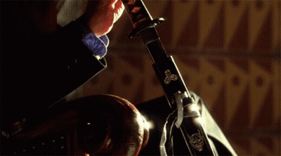 A Person Is Holding A Sword In Their Hand GIF