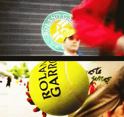 A Person Is Holding A Tennis Ball That Says Roland Garros GIF