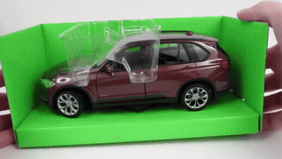 A Person Is Holding A Toy Car In A Green Box With The Door Open GIF