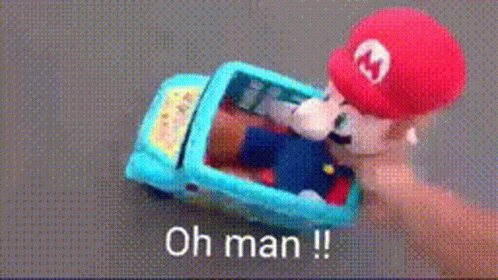 A Person Is Holding A Toy Mario In A Car With The Words Oh Man Written On The Bottom GIF