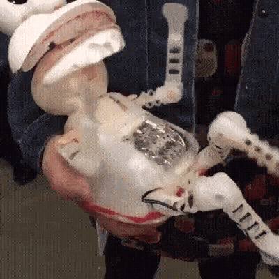 A Person Is Holding A Toy That Looks Like A Skeleton With A Mouth Open GIF