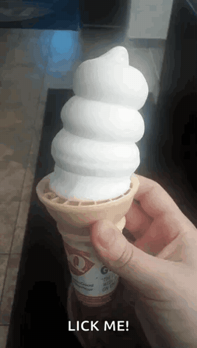 A Person Is Holding A Vanilla Ice Cream Cone That Says Lick Me GIF