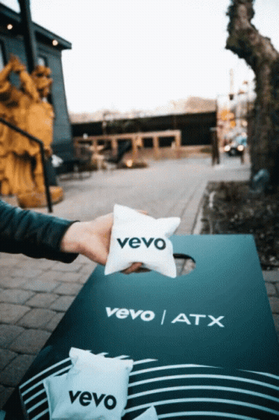A Person Is Holding A Vevo Pillow Over A Vevo Atx Board GIF