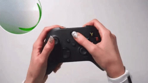 A Person Is Holding A Video Game Controller In Their Hands GIF