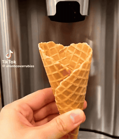 A Person Is Holding A Waffle Cone With Tiktok Written On It GIF