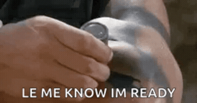 A Person Is Holding A Watch On Their Wrist And The Words `` Le Me Know Im Ready '' Are Visible . GIF