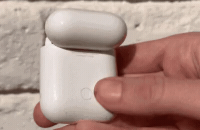A Person Is Holding A White Case With A Button On The Side GIF