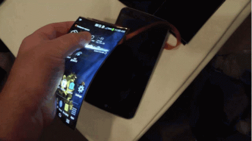 A Person Is Holding An Lg Phone That Is Displaying The Time As 11:59 GIF