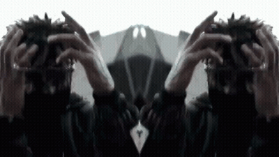 A Person Is Holding Their Hands To Their Head And Looking At A Mirror . GIF