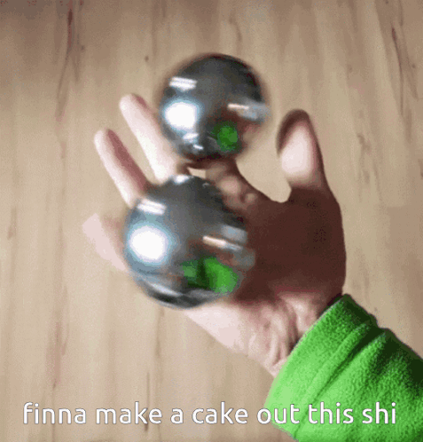 A Person Is Holding Two Metal Balls In Their Hand With The Words Finna Make A Cake Out This Shi Below Them GIF