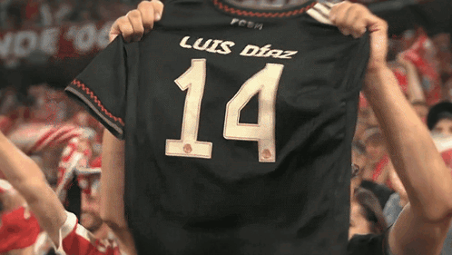 A Person Is Holding Up A Jersey That Says Luis Diaz 14 GIF