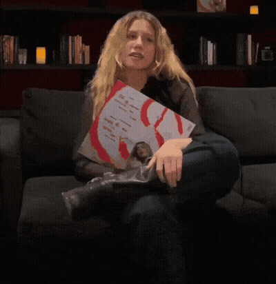 A Person Is Holding Up A Picture Of A Man With A Red S On His Chest GIF