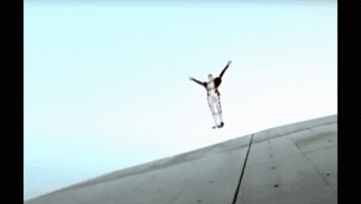 A Person Is Jumping In The Air With Their Arms Outstretched .. GIF