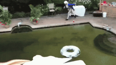 A Person Is Jumping Into A Swimming Pool With A Donut Floating In It GIF