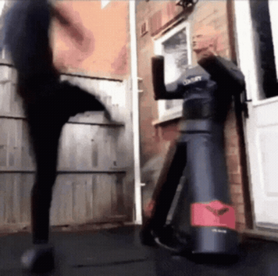 A Person Is Kicking A Dummy That Says Century On It GIF