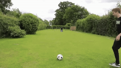A Person Is Kicking A Soccer Ball In A Field GIF