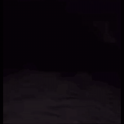 A Person Is Laying On A Bed With A Ghost Behind Them . GIF