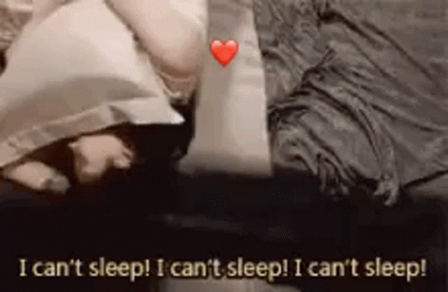 A Person Is Laying On A Bed With A Pillow And A Heart . GIF