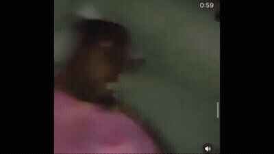 A Person Is Laying On A Bed With A Pink Blanket And Headphones . GIF