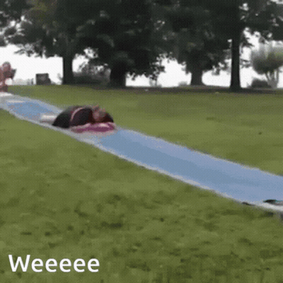 A Person Is Laying On A Blue Slide With The Words Weeeee Below It GIF