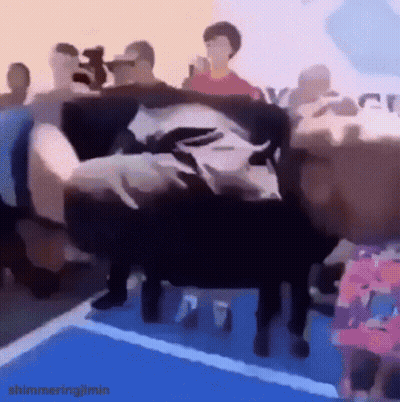 A Person Is Laying On A Couch In Front Of A Crowd . GIF