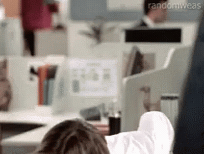 A Person Is Laying On A Desk With Their Feet Up In An Office . GIF