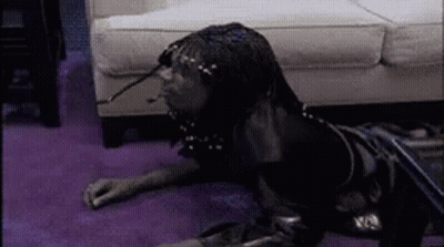 A Person Is Laying On The Floor In Front Of A Couch . GIF