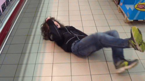 A Person Is Laying On The Floor In Front Of A Display Of Zap GIF