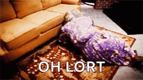 A Person Is Laying On The Floor Next To A Couch With The Words `` Oh Lort '' Written On The Rug . GIF