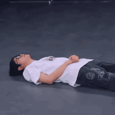 A Person Is Laying On The Floor With Their Hands On Their Hips GIF
