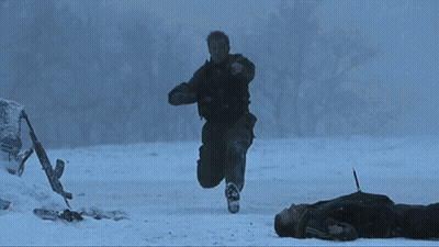 A Person Is Laying On The Ground Holding A Gun GIF