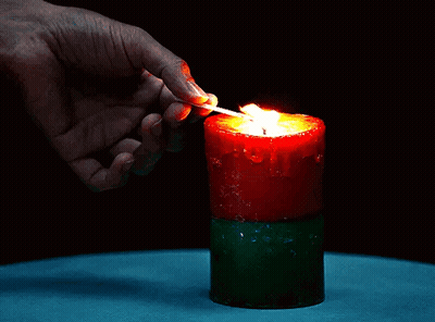 A Person Is Lighting A Red Candle With A Match GIF