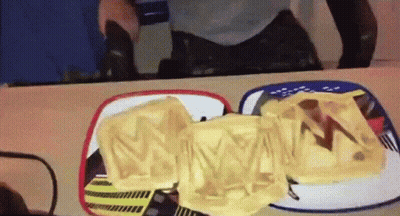 A Person Is Looking At Their Reflection In A Mirror While Eating A Sandwich With The Letter M On It GIF