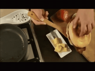 A Person Is Making A Sandwich With A Wooden Spoon GIF