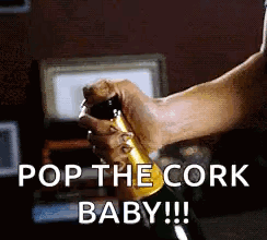 A Person Is Opening A Bottle Of Champagne With The Words `` Pop The Cork Baby '' Written On It . GIF