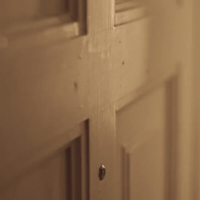 A Person Is Opening A Door With A Knife In Their Hand . GIF