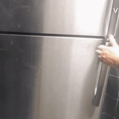 A Person Is Opening A Stainless Steel Refrigerator With The Word Vi On The Bottom GIF