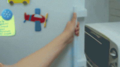 A Person Is Opening The Door Of A Refrigerator With A Yellow Item In It GIF