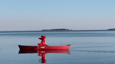 A Person Is Paddling A Red Coleman Canoe In The Water GIF