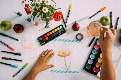 A Person Is Painting A Flower On A Piece Of Paper With A Palette Of Watercolors GIF
