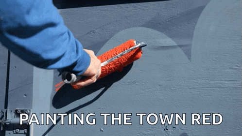 A Person Is Painting The Town Red With A Red Paint Roller GIF