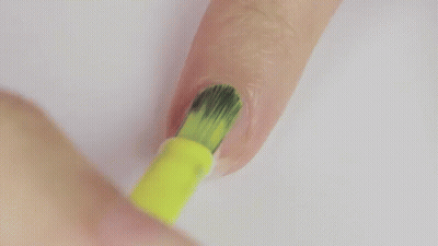 A Person Is Painting Their Nails With A Yellow Nail Polish Brush . GIF
