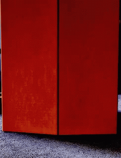 A Person Is Peeking Out From Behind A Door GIF