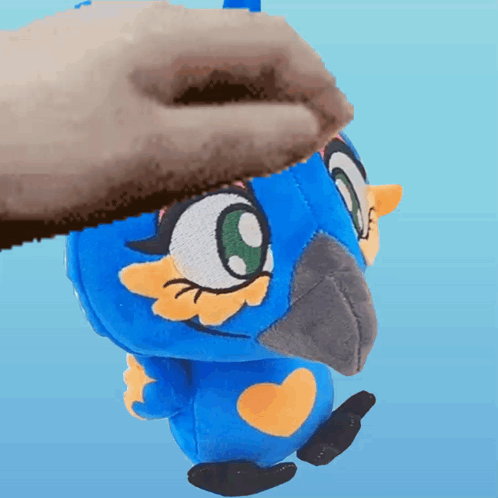 A Person Is Petting A Blue Stuffed Animal With A Yellow Heart On Its Chest GIF